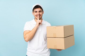 Wall Mural - Delivery caucasian man isolated on blue background doing silence gesture