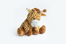 Plush Toy Giraffe Isolated On A White Background Colorful Plush Toy. Colored Stuffed Toy-giraffe. White And Brown Giraffe