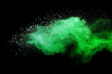 Green powder explosion on black background.