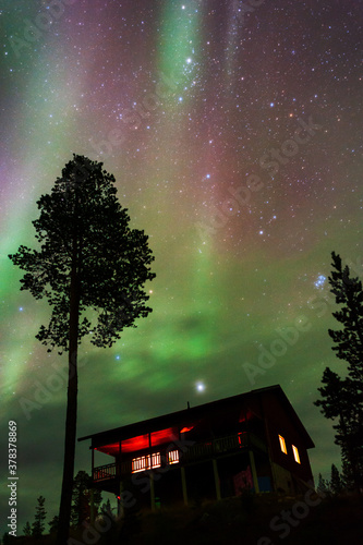 Cuadros en Lienzo Night sky with Aurora Borealis, planet Jupiter and The Pleiades above country house