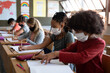 © Wavebreak Media - Group of kids wearing face masks studying in class at school