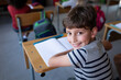 © Wavebreak Media - Portrait of smiling boy sitting at desk in school