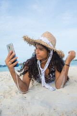 Young african american teenager woman taking a selfie to share social media in Caribbean beach