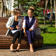 © Andrey_Arkusha - Two young female students met in a summer park