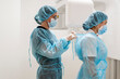 © Javier De La Torre Sebastian/Westend61 - Female doctor tying nurse's protective wear at clinic
