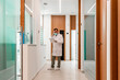 © Javier De La Torre Sebastian/Westend61 - Dentist reading file while talking on phone in corridor at hospital