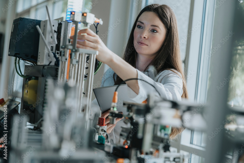 Confident female engineer inventing machinery in laboratory Stock Photo ...