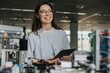 © Mareen Fischinger/Westend61 - Smiling female scientist holding digital tablet looking away while standing by machinery in laboratory