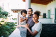 © Eugenio Marongiu/Westend61 - Smiling parents standing with daughter sitting on retaining wall in balcony