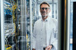 © Mareen Fischinger/Westend61 - Male IT professional standing by network server in date center seen through glass