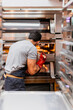 © Manu Reyes/Westend61 - Male baker baking bread in oven at bakery