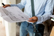 © VALENTINA BARRETO STUDIO/Westend61 - Architect holding plan in a house under construction
