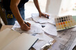 © VALENTINA BARRETO STUDIO/Westend61 - Man working on construction plan and colour swatch