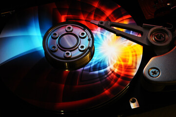 Wall Mural - closeup of computer open hard disk drive with colored abstract effect reflected