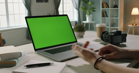 Wall Mural - Close up shot of hands of remote worker gesturing near green screen laptop during video chat with employees or conference with customers - communnications concept 4k video template