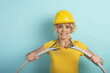 © alphaspirit - Worker woman with hat breaks an electric cable. Cyan background