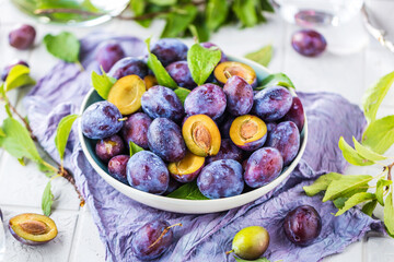 close-up view of bowl with fresh plums on table