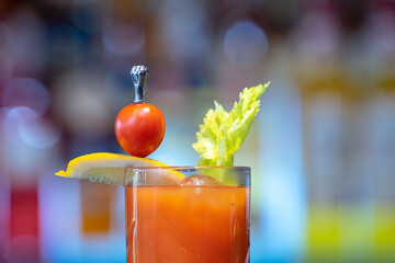 Wall Mural - Closeup shot of a glass of iced cocktail with lettuce and berries on a bar counter