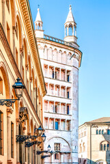 The baptistery of Parma in Piazza Duomo seen from the street with typical yellow buildings, in Parma historical center, Emilia Romagna region, Italy. 