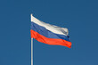 Russia flag is on a pole against a blue sky