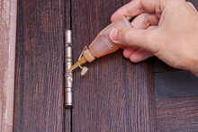 Adjusting Door Hinge Using Lubricating Oil. Indoors. Fixing Door Squealed Domestic Problem