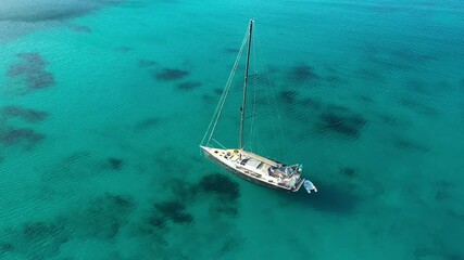 Wall Mural - View from above, stunning aerial view of a white sailboat, floating on a turquoise, clear water. Sardinia, Italy. Sardinia is the second-largest island in the Mediterranean Sea.