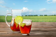 © Pixel-Shot - Glass and jug of tasty cold ice tea on table outdoors