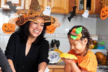 Wall Mural - A woman with a kid carving a pumpkin