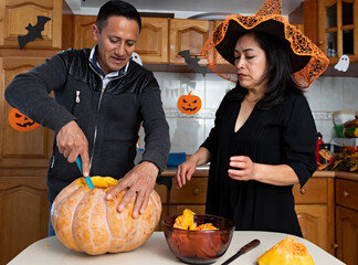 Wall Mural - A couple carving a pumpkin in Halloween