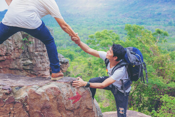 Wall Mural - Close up of hand helping each other hike up a mountain. Help and support concept.	