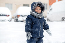 Adorable Baby Boy In A Warm White Snow Suit Walking On Snow.
