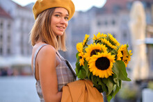 Young Fashion  Woman With A Bouquet Of Sunflowers In The City