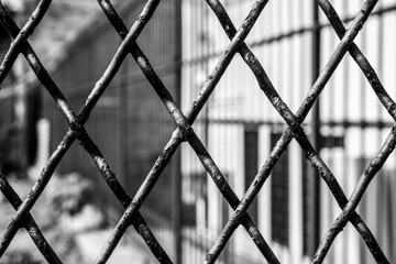 black and white texture of trapeze shaped iron grate of a gate