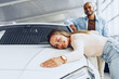 © fotofabrika - Young couple man and woman hugging their new car in a car shop