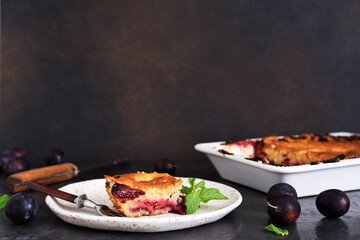 Wall Mural - Vanilla muffin with plums and mint on a dark concrete background. Fruit pie.