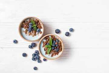 Wall Mural - Healthy breakfast of berry yogurt with chocolate granola and blueberry