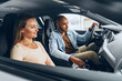 © fotofabrika - Joyful young couple looking around inside a new car they are going to buy in a car shop