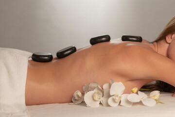 Woman getting a hot stone massage at spa salon