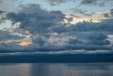 Fototapeta Morze - evening bright sunset with silvery gray blue clouds on lake baikal with a mountains ridge on the horizon