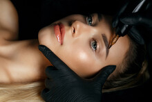Woman In Gloves Applying Eyebrow Tattoo