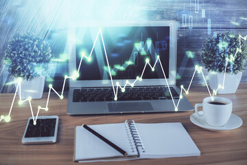 Financial graph colorful drawing and table with computer on background. Double exposure. Concept of international markets.