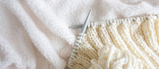 knitting white wool yarn pattern. Closeup horizontal photo. Freelance creative handicraft concept, hobby and lifestyle