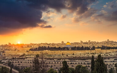 Dramatic sunset sky over Mount Zion and Old City Jerusalem; view of the Temple Mount with Dome of the Rock and Golden Gate, Kidron Valley in the foreground, and the skyline of West Jerusalem