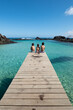 © acongar - Three children are sitting on the wooden pier in  Isla de Lobos, Canary Islands, Spain.