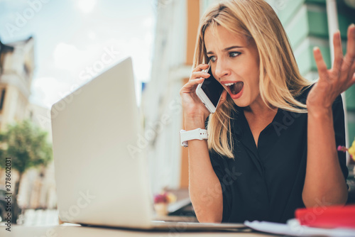 Fotografía Puzzled female freelancer calling to colleague for solving problems in online mo
