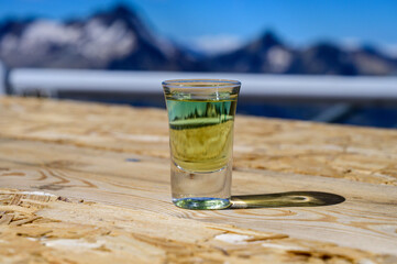 Tasting of very sweet french green strong liqueur based on many herbs, plants and flowers from Chartreuse abbey in Alpine mountains