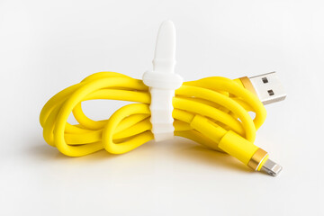 Yellow usb cable for charging a mobile phone on a white background. silicone mobile phone accessory