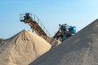 © Michal - Conveyor belt over heaps of gravel against the blue sky at an industrial cement plant.