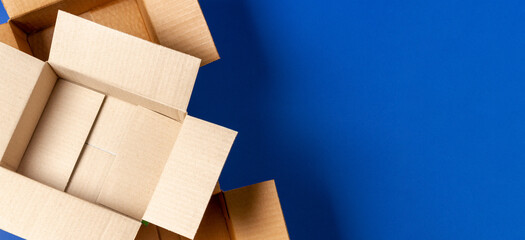 Empty open cardboard boxes on blue background. Top view