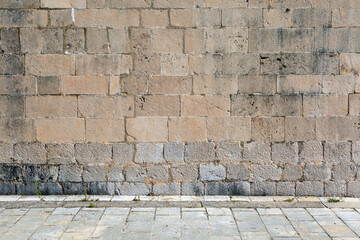  Exterior detail of an old Mediterranean historic building, stone wall facade and street.